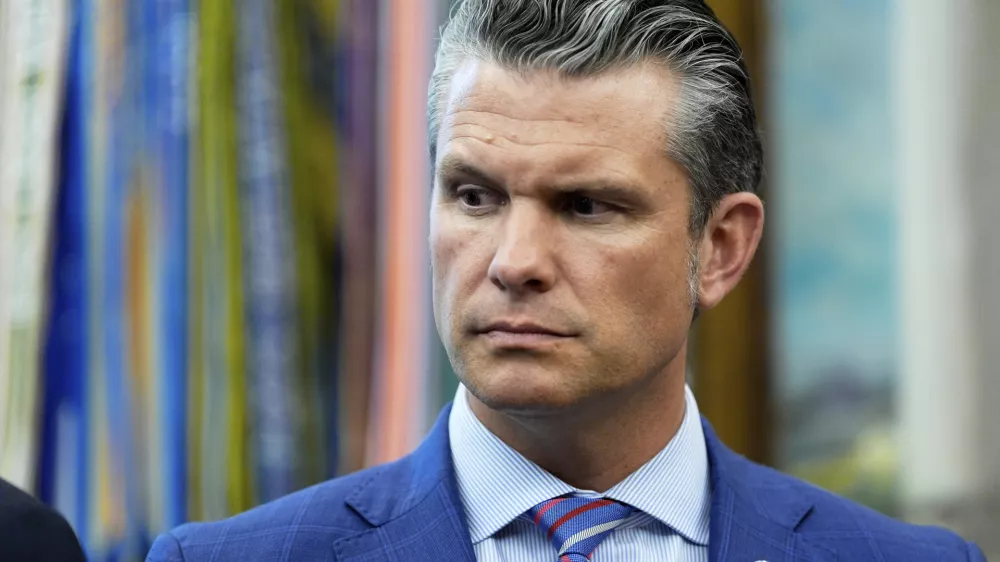 Defense Secretary Pete Hegseth listens as President Donald Trump speaks in the Oval Office of the White House, Monday, Sept. 15, 2025, in Washington. (AP Photo/Alex Brandon)