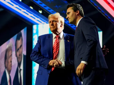 FILE PHOTO: U.S. President-elect Donald Trump shakes hands with Turning Point USA founder Charlie Kirk, at Turning Point USA's AmericaFest in Phoenix, Arizona, U.S., December 22, 2024. REUTERS/Cheney Orr//File Photo