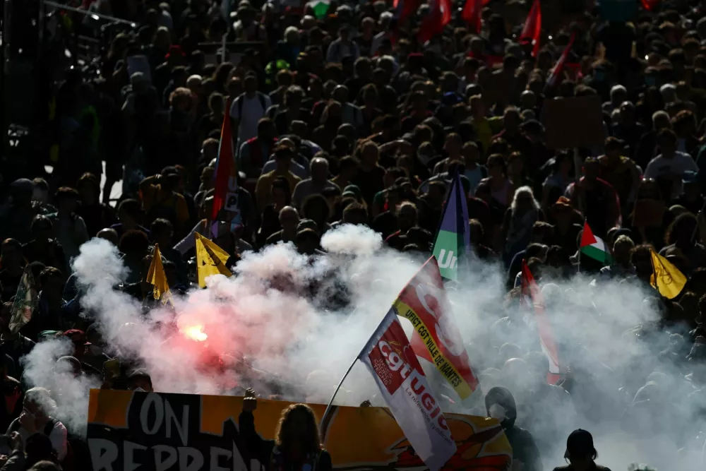 Protesters hold flares and labour union flags duringa demonstration in Nantes as part of a day of nationwide strikes and protests against the government and cuts in the next budget, with supporters of the "Bloquons Tout" (Let's Block Everything) movement, France, September 18, 2025. REUTERS/Stephane Mahe