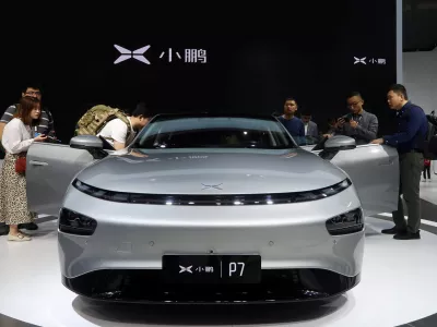 ﻿FILE PHOTO: People look at XPeng's P7 sedan model displayed at the Guangzhou auto show in Guangzhou, Guangdong province, China November 22, 2019. Picture taken November 22, 2019. REUTERS/Yilei Sun/File Photo