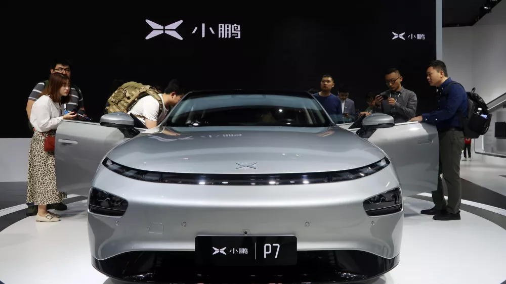 ﻿FILE PHOTO: People look at XPeng's P7 sedan model displayed at the Guangzhou auto show in Guangzhou, Guangdong province, China November 22, 2019. Picture taken November 22, 2019. REUTERS/Yilei Sun/File Photo