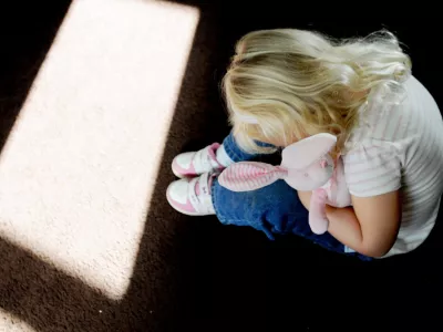 DHF9WT A small girl holding a bunny rabbit in silhouette picture posed by model abuse, child abuse, neglect, child grooming