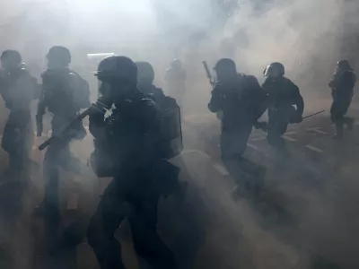 French gendarmes and riot police charge amid tear gas during clashes with protesters at a demonstration in Paris as part of a day of nationwide strikes and protests against the government and cuts in the next budget, with supporters of the "Bloquons Tout" (Let's Block Everything) movement, France, September 18, 2025. REUTERS/Tom Nicholson