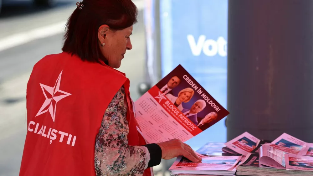 A participant of the Patriotic Electoral Bloc's campaign sorts leaflets while agitating voters in a street ahead of Moldova's upcoming parliamentary elections in Chisinau, Moldova, September 21, 2025. REUTERS/Vladislav Culiomza