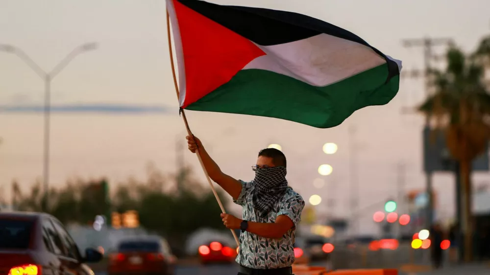 A man holds a Palestinian flag as he attends a demonstration in support of Palestinians and the Global Sumud Flotilla, amid the ongoing conflict in Gaza, outside the U.S. Consulate in Ciudad Juarez, Mexico, September 20, 2025. REUTERS/Jose Luis Gonzalez