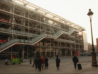 FILE - People walk in front of the Georges Pompidou Center in Paris on Jan. 28, 1997. Richard Rogers, the lauded British architect who was one of the forces behind the Pompidou Center in Paris and later designed London's Millennium Dome has died. He was 88. Rogers Stirk Harbour + Partners, the company he founded, confirmed his death in a statement Sunday Dec. 19, 2021. (AP Photo/Remy de la Mauviniere, File)