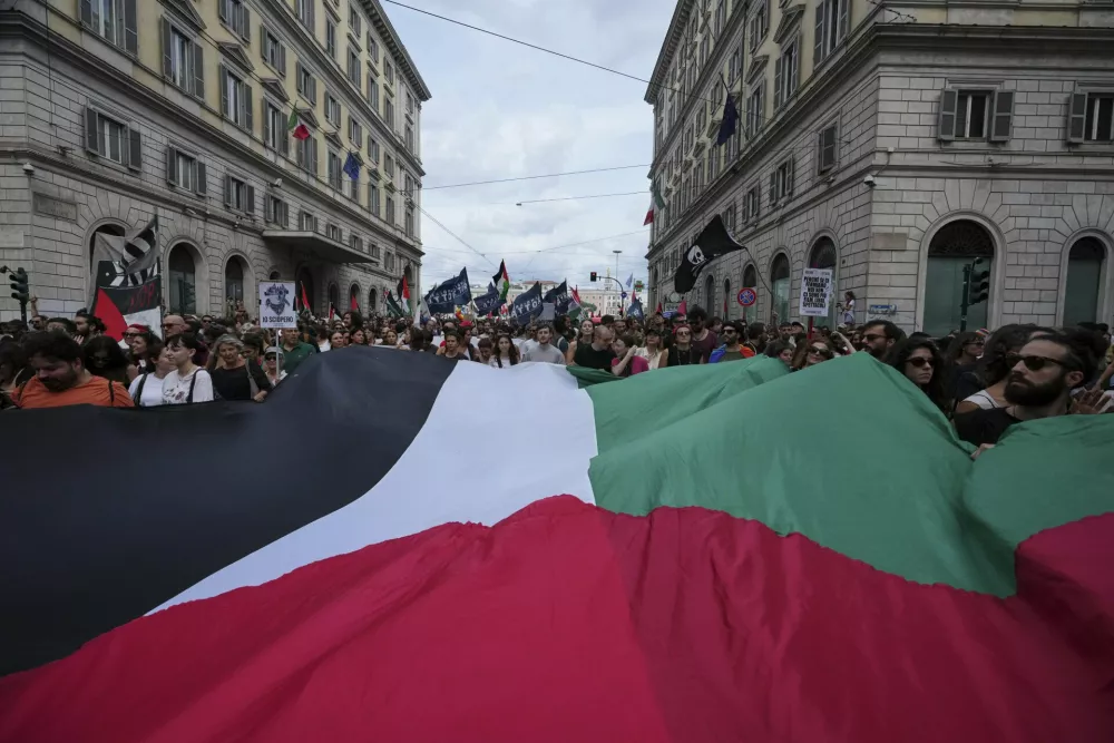 People hold giant Palestinian flag as they participate at a demonstration part of a nation-wide protest and general strike against the killings in Gaza, in Rome, Monday, Sept. 22, 2025. (AP Photo/Alessandra Tarantino)