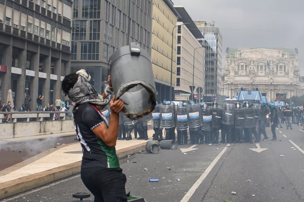 22 September 2025, Italy, Milan: A demonstrator throws an object towards Police forces during clashes at a pro-palestine demonstration in Milan. A nationwide strike in solidarity with the people of Gaza caused disruptions across Italy on Monday. Photo: Claudio Furlan/LaPresse via ZUMA Press/dpa