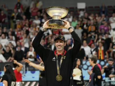 Basketball - FIBA EuroBasket 2025 - Final - Turkey v Germany - Xiaomi Arena, Riga, Latvia - September 14, 2025 Germany head coach Alex Mumbru holds the trophy after winning the FIBA EuroBasket final REUTERS/Ints Kalnins / Foto: Ints Kalnins