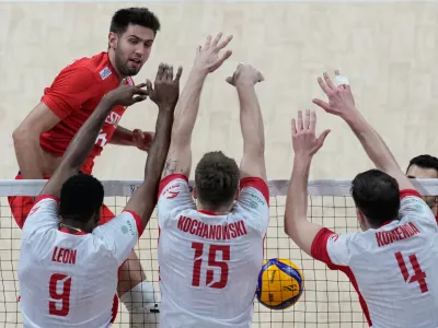 Polish players foreground from left, Wilfredo Leon Venero, Jakub Kochanowski and Marcin Komenda blocked a shot from Mirza Lagumdzija, of Turkey during the quarterfinals at the 2025 FIVB Volleyball Men's World Championship at the Mall of Asia Arena, in Pasay city, Philippines on Wednesday Sept. 24, 2025. (AP Photo/Aaron Favila)