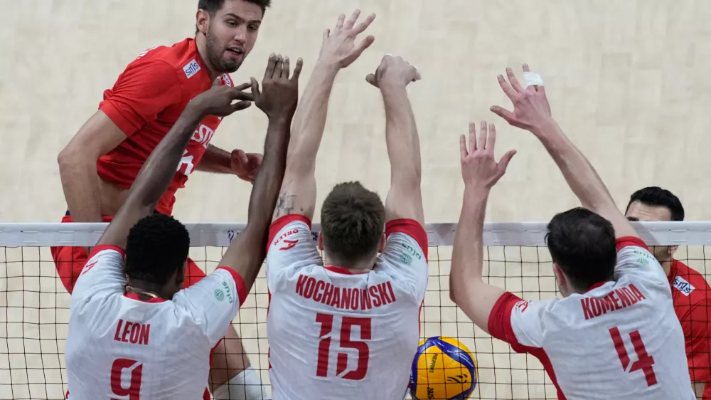 Polish players foreground from left, Wilfredo Leon Venero, Jakub Kochanowski and Marcin Komenda blocked a shot from Mirza Lagumdzija, of Turkey during the quarterfinals at the 2025 FIVB Volleyball Men's World Championship at the Mall of Asia Arena, in Pasay city, Philippines on Wednesday Sept. 24, 2025. (AP Photo/Aaron Favila)