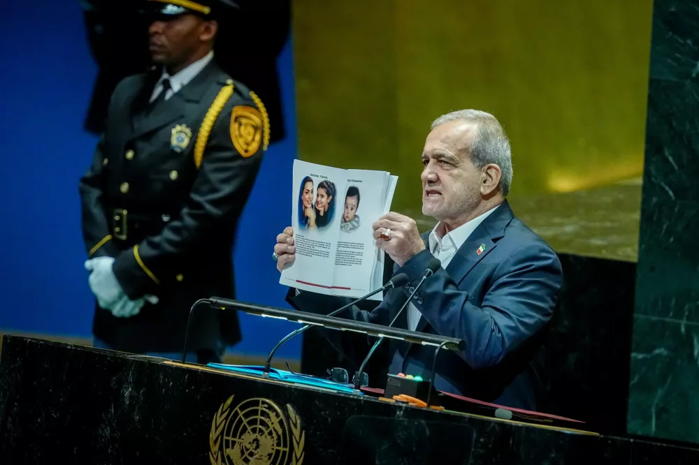 24 September 2025, US, New York: Iranian President Masoud Pezeshkian speaks at the general debate of the UN General Assembly in New York, showing a book with pictures with the inscription "Killed by Israel". Over 140 heads of state and government are expected to attend the world's largest diplomatic event over several days. Photo: Kay Nietfeld/dpa
