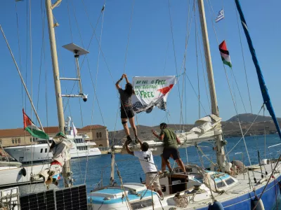People hang a banner before the departure of the sailing boats Electra and Oxygen, part of the Global Sumud Flotilla, from the port of Ermoupolis on Syros island, Greece, September 14, 2025. REUTERS/Giorgos Solaris