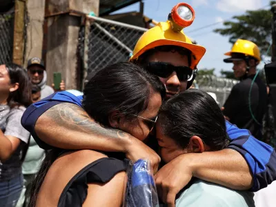 A miner embraces his relatives after he was rescued from a gold mine that had collapsed in Segovia, Colombia, Wednesday, Sept. 24, 2025. (AP Photo/Santiago Saldarriaga)