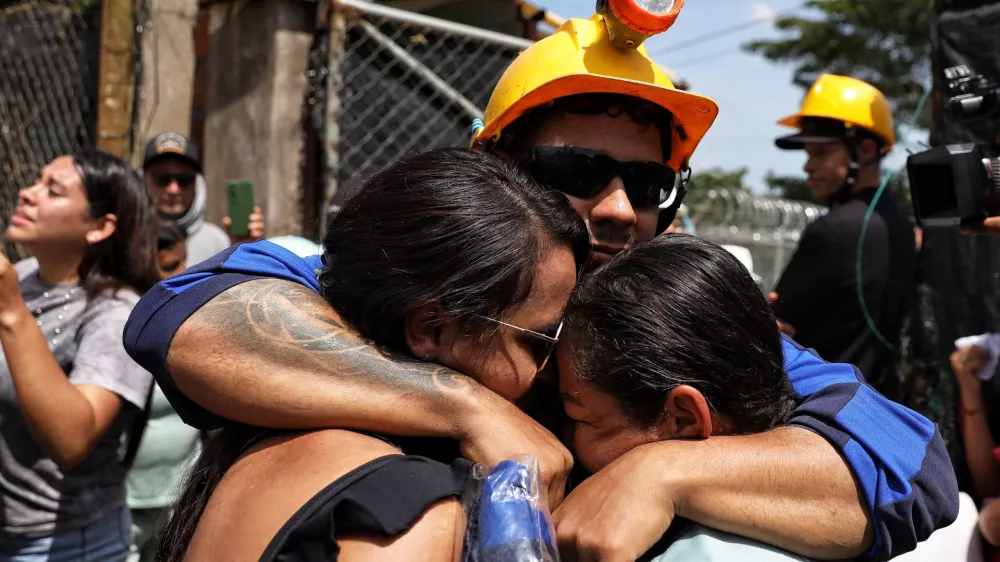 A miner embraces his relatives after he was rescued from a gold mine that had collapsed in Segovia, Colombia, Wednesday, Sept. 24, 2025. (AP Photo/Santiago Saldarriaga)