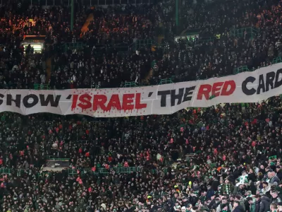 FILE - Celtic fans lift a protest banner about Israel during the Champions League playoff first leg soccer match between Glasgow Celtic and Bayern Munich at the Celtic Park Stadium in Glasgow, Scotland, Wednesday, Feb. 12, 2025. (AP Photo/Scott Heppell, File)