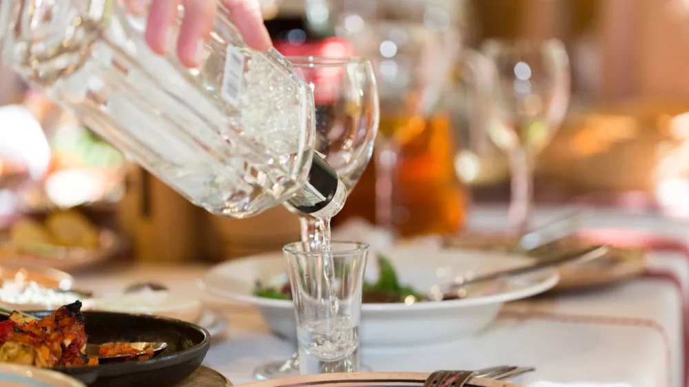 ﻿Feast in a restaurant, pouring vodka into the glass closeup