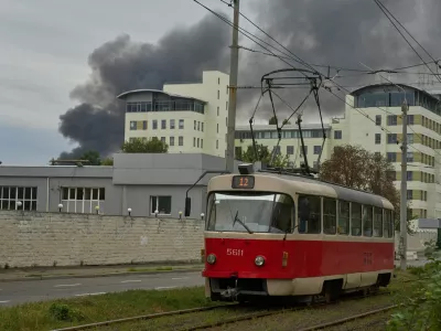 A public tram runs against the background of rising smoke during Russia's massive drone and missile attack in Kyiv, Ukraine, Sunday, Sept. 28, 2025. (AP Photo/Efrem Lukatsky)