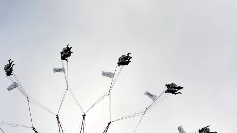 27 September 2025, Bavaria, Munich: Visitors ride a giant chain carousel at the 190th Oktoberfest beer festival in Munich. Photo: Felix Hörhager/dpa