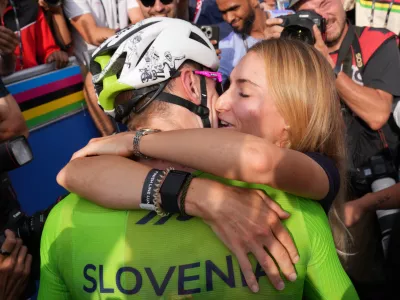 Slovenia's Tadej Pogacar celebrates with his partner Urska Zigart after winning the men's Elite road race, at the road cycling World Championships in Kigali, Rwanda, Sunday, Sept. 28, 2025. (AP Photo/Jerome Delay)
