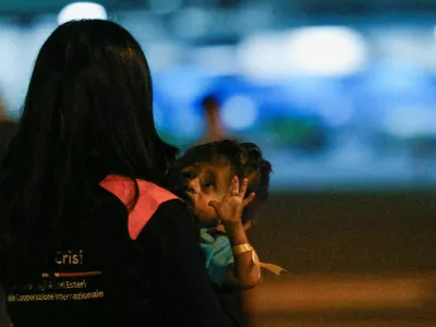 A person holds a Palestinian child who was evacuated from Gaza via a humanitarian airlift and arrived in Italy with relatives for medical treatment, at Ciampino Military Airport in Ciampino, Italy September 29, 2025. REUTERS/Francesco Fotia