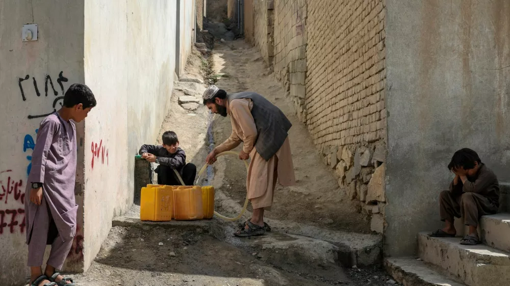 Shopkeeper Assadullah collects water from a neighbour's tap, amid serious water crisis in Kabul, Afghanistan, September 14, 2025. REUTERS/Sayed Hassib