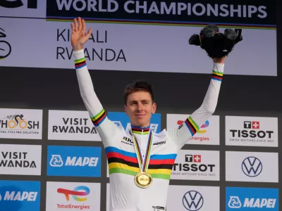Slovenia's Tadej Pogacar celebrates on the podium after winning the men's Elite road race, at the road cycling World Championships in Kigali, Rwanda, Sunday, Sept. 28, 2025. (AP Photo/Jerome Delay)