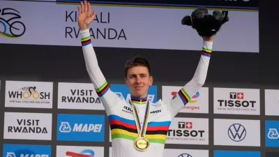 Slovenia's Tadej Pogacar celebrates on the podium after winning the men's Elite road race, at the road cycling World Championships in Kigali, Rwanda, Sunday, Sept. 28, 2025. (AP Photo/Jerome Delay)
