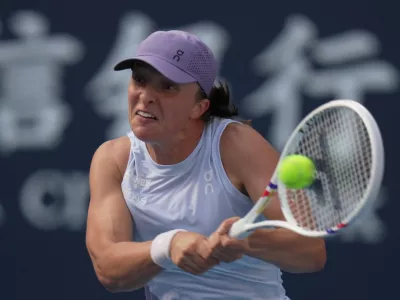 Iga Swiatek, of Poland plays a backhand return to Camila Osorio, of Colombia during the women's singles match for the China Open tennis tournament, at the National Tennis Center, in Beijing, Monday, Sept. 29, 2025. (AP Photo/Andy Wong)