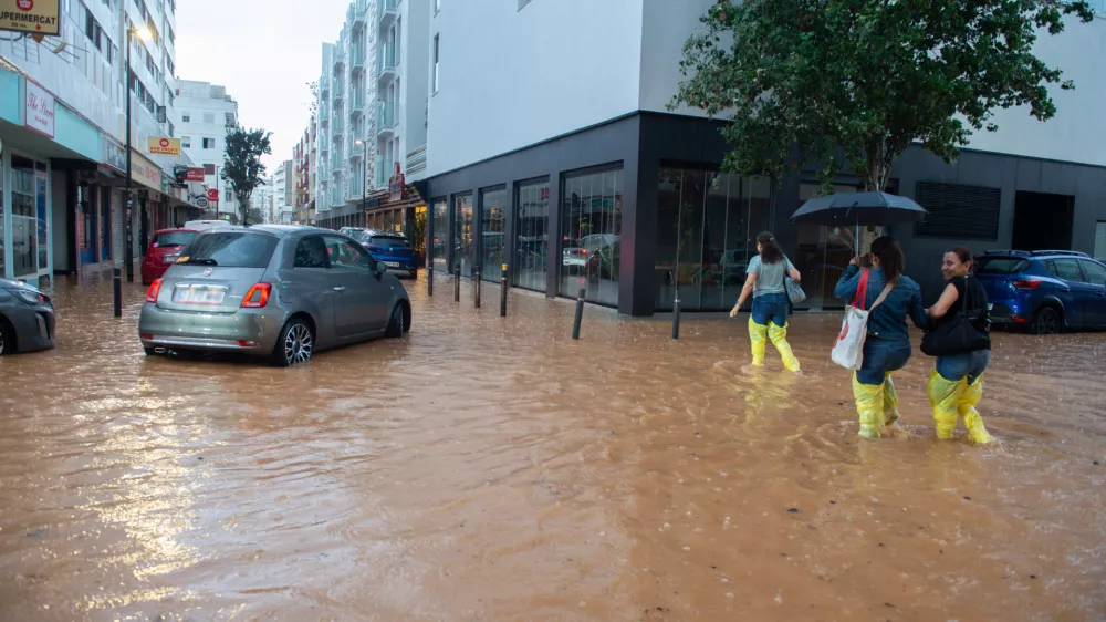 30 September 2025, Spain, Ibiza: People walk along a flooded street in the Balearic city of Ibiza after a heavy rainfall. Photo: Germán Lama/EUROPA PRESS/dpa