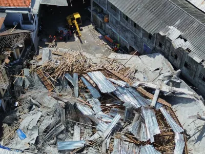 This aerial shot taken with a drone shows rescuers searching for victims trapped under the rubble after a building under construction collapsed Monday at an Islamic boarding school in Sidoarjo, East Java, Indonesia, Wednesday, Oct. 1, 2025. (AP Photo/Trisnadi)