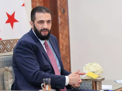 FILE - In this photo released by the Syrian official news agency SANA, Syria's interim President Ahmad al-Sharaa receives the final version of the provisional electoral system for the People's Assembly, in Damascus, Syria, Sunday, July 27, 2025. (SANA via AP, file)