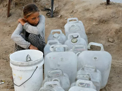 A displaced Palestinian girl waits to collect water after Hamas agreed to release hostages and accept some other terms in a U.S. plan to end the war, in the central Gaza Strip October 4, 2025. REUTERS/Mahmoud Issa