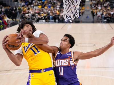 Los Angeles Lakers center Jaxson Hayes, left, grabs a rebound away from Phoenix Suns center Oso Ighodaro during the second half of an NBA preseason basketball game Friday, Oct. 3, 2025, in Palm Desert, Calif. (AP Photo/Mark J. Terrill)