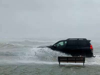 A car drives through a flooded park next to the sea during Storm Amy which brought severe weather, in Galway, Ireland, October 3, 2025. REUTERS/Clodagh Kilcoyne