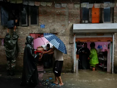 Members of Nepal Army help people retrieve their belongings to a safe area at a flooded street along the bank of overflowing Bagmati River following heavy rains, in Kathmandu, Nepal, October 4, 2025. REUTERS/Navesh Chitrakar