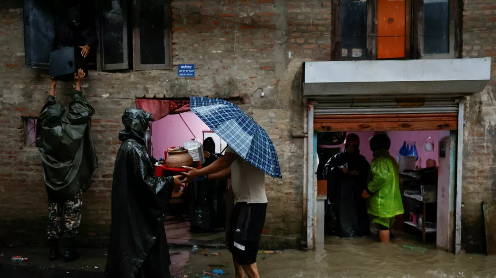 Members of Nepal Army help people retrieve their belongings to a safe area at a flooded street along the bank of overflowing Bagmati River following heavy rains, in Kathmandu, Nepal, October 4, 2025. REUTERS/Navesh Chitrakar