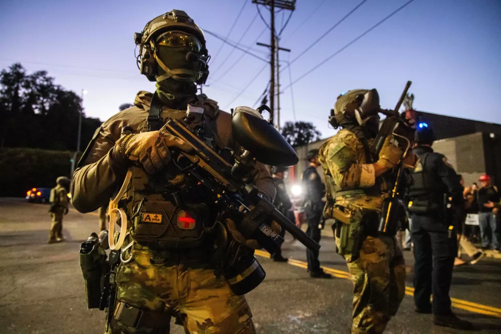 Federal enforcement officers stand guard near a U.S. Immigration and Customs Enforcement facility in Portland, Ore., Monday, Oct. 6, 2025. (AP Photo/Ethan Swope)
