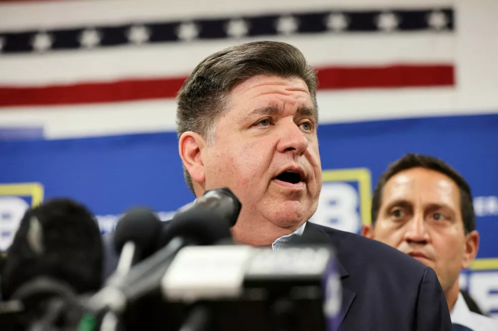 FILE PHOTO: llinois Governor J.B. Pritzker speaks near Texas State Rep. Trey Martinez as Democratic lawmakers from Texas hold a press conference, after they had left their state to deny Republicans the quorum needed to redraw the state's 38 congressional districts, in Carol Stream, Illinois, U.S. August 3, 2025. REUTERS/Tom Krawczyk/File Photo