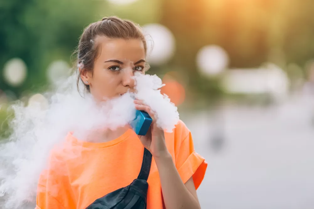 ﻿Pretty young girl vape popular ecig gadget,vaping device.Happy brunette vaper girl with e-cig.Portrait of smoker female model with electronic cigarette vaporizer.Ejuice vaping with fruit flavor liquid