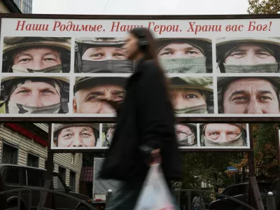 A woman walks past a gallery of portraits of Russian service members involved in the country's military campaign in Ukraine, that is placed in a street near the office of a charity fund collecting donations on vehicles for the use of Russia's army during a conflict against Ukraine, in Saint Petersburg, Russia, October 6, 2025. A slogan on the board reads: "Our dear ones. Our heroes. God bless you!" REUTERS/Anton Vaganov