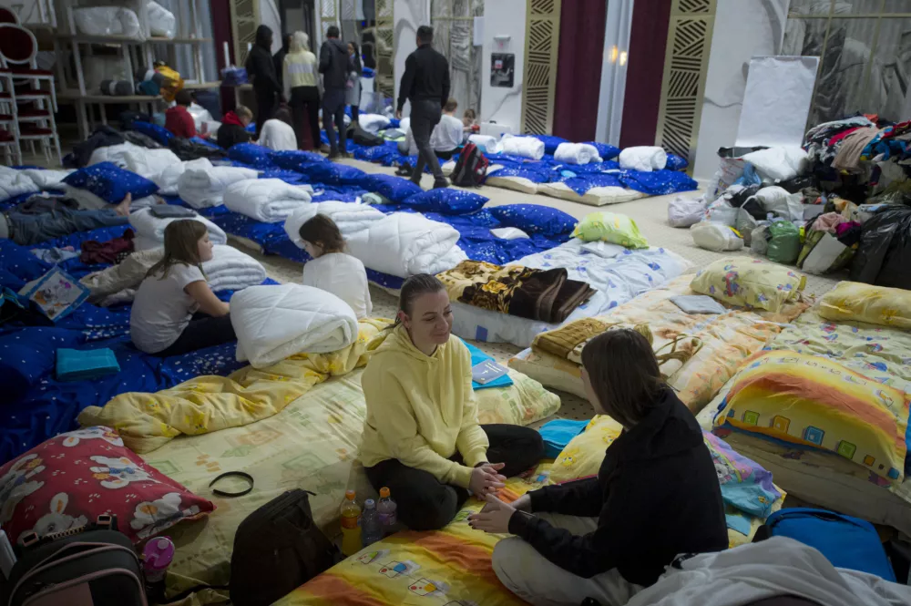 ﻿Refugees fleeing the conflict from neighbouring Ukraine talk in the event hall of a hotel offering shelter in Siret, Romania, Saturday, Feb. 26, 2022. Romania, which shares around 600 kilometres (372 miles) of borders with Ukraine to the north, is seeing an influx of refugees from the country as many flee Russia's attacks. (AP Photo/Alexandru Dobre)