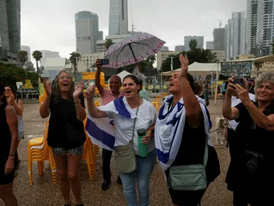 People celebrate after U.S. President Donald Trump announced that Israel and Hamas agreed on the first phase of a Gaza ceasefire, at the "Hostages square", in Tel Aviv, Israel, October 9, 2025. REUTERS/Ronen Zvulun