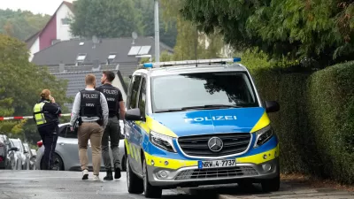 Police officers across a street in Herdecke, Germany, Tuesday, Oct. 7, 2025, after the newly elected mayor of Herdecke, Iris Stalzer, has been found critically injured in her apartment. (AP Photo/Martin Meissner)