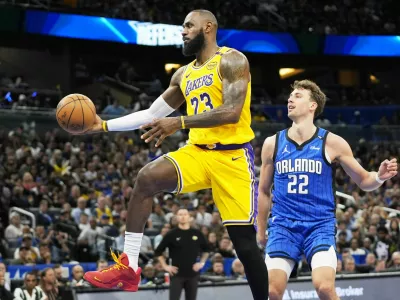 Los Angeles Lakers forward LeBron James (23) passes the ball as he gets past Orlando Magic forward Franz Wagner (22) during the first half of an NBA basketball game, Monday, March 24, 2025, in Orlando, Fla. (AP Photo/John Raoux)