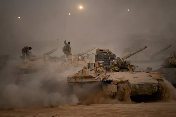 Israeli soldiers drive a tank along the Israeli-Gaza border, as seen from southern Israel, Friday, Oct. 10, 2025, after Israel and Hamas have agreed to a pause in their war and the release of the remaining hostages. (AP Photo/Emilio Morenatti)