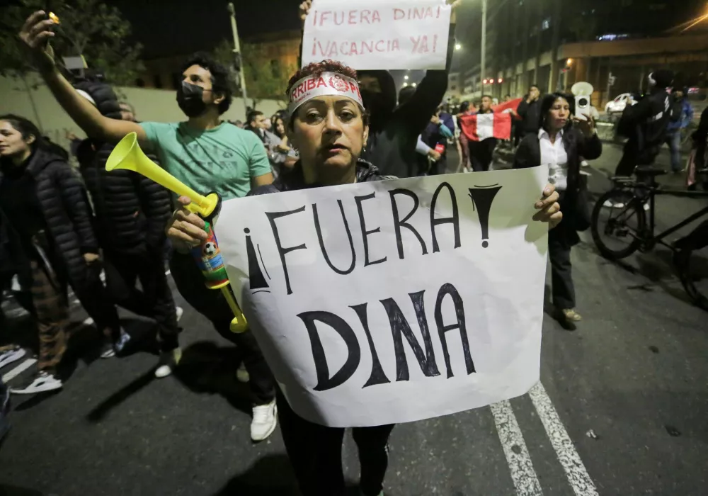 A woman holds a sign reading "Dina Out" after Peru's Congress voted unanimously to remove President Dina Boluarte from office, in Lima, Peru October 9, 2025. REUTERS/Gerardo Marin