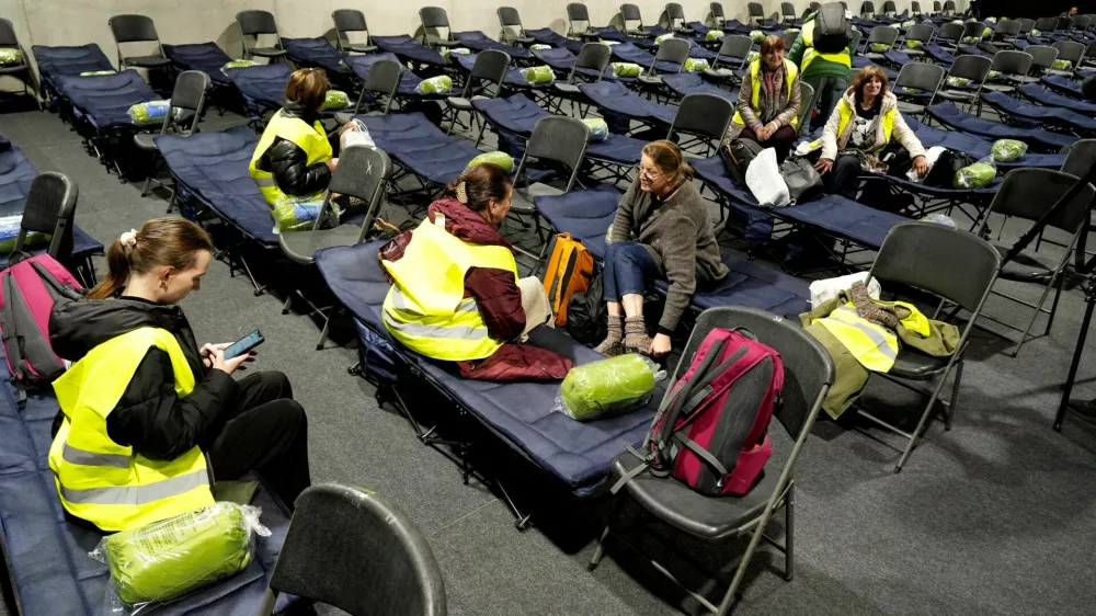 FILE PHOTO: Volunteers who participate as evacuees during a drill in case of military conflict sit on chairs and beds in the evacuation center set up in the athletics hall in Kaunas, Lithuania October 7, 2025. REUTERS/Ints Kalnins/File Photo
