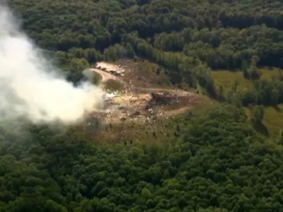 Smoke fills the air as debris covers the ground and vehicles after a powerful blast ripped through a military explosives manufacturing plant in Hickman County, Tenn., on Friday, Oct. 10, 2025.  (WTVF-TV via AP)