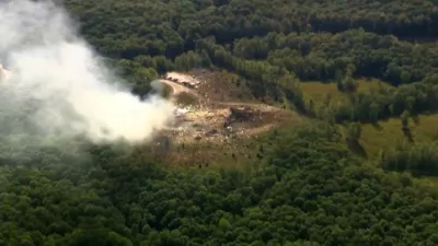Smoke fills the air as debris covers the ground and vehicles after a powerful blast ripped through a military explosives manufacturing plant in Hickman County, Tenn., on Friday, Oct. 10, 2025.  (WTVF-TV via AP)